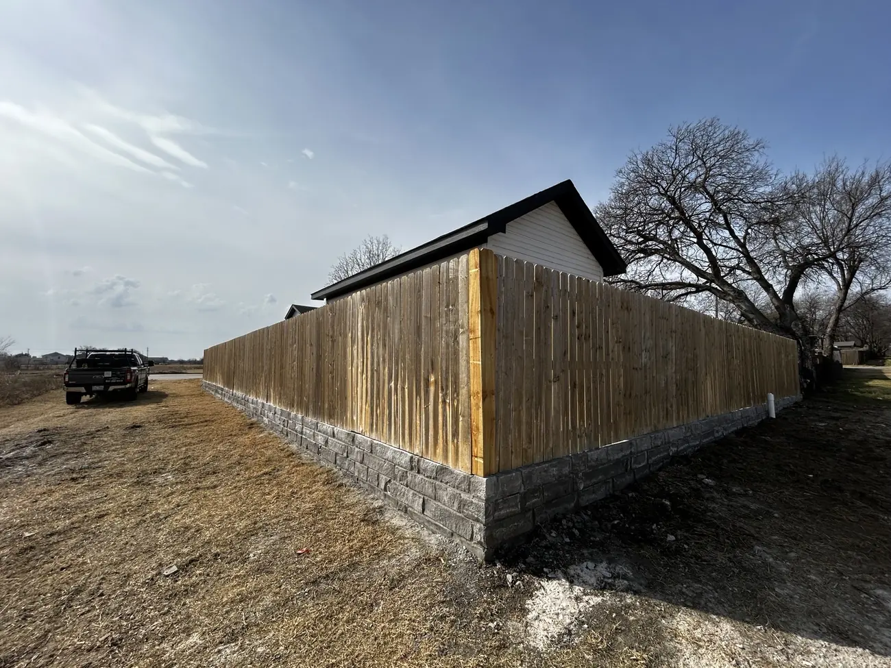 Wood privacy fence installed over masonry base